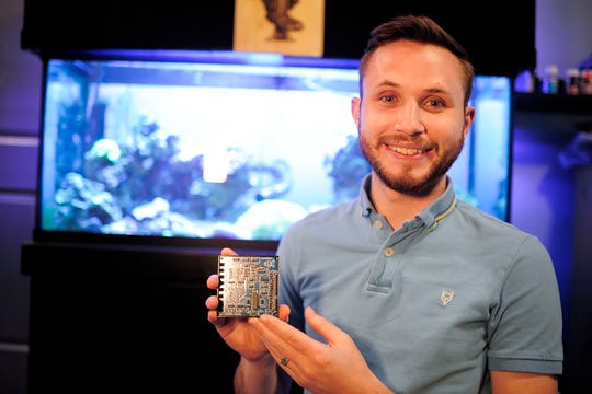 Brandon Schrieber holds one of his Leviathan Aquarium and Automation circuit boards May 5 at his home in Halls, Tenn. Schreiber is the winner of the What's the Big Idea pitch competition.