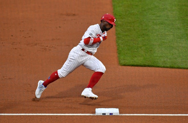 Andrew McCutchen rounds third and heads home with the Phillies' first run in the first inning against the Brewers.