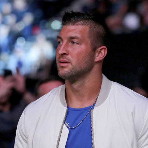 Tim Tebow is seen by the octagon during UFC 261 at