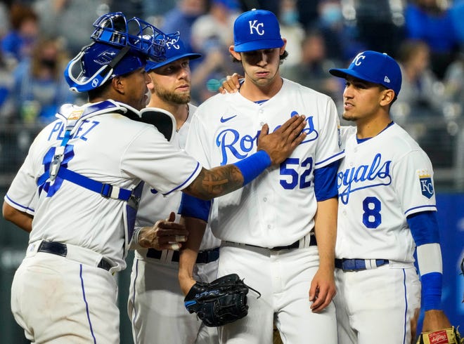 Royals starting pitcher Daniel Lynch (52) is surrounded by catcher Salvador Perez (13) and third baseman Hunter Dozier (17) and shortstop Nicky Lopez (8) as he comes out of the game in the fifth inning May 3 against the Cleveland Indians at Kauffman Stadium.