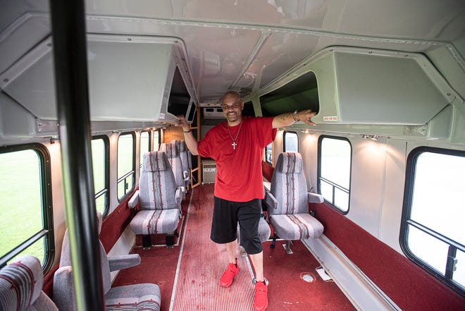 Jemar Harris stands in what will soon be a bus that will be converted into a mobile barbershop.