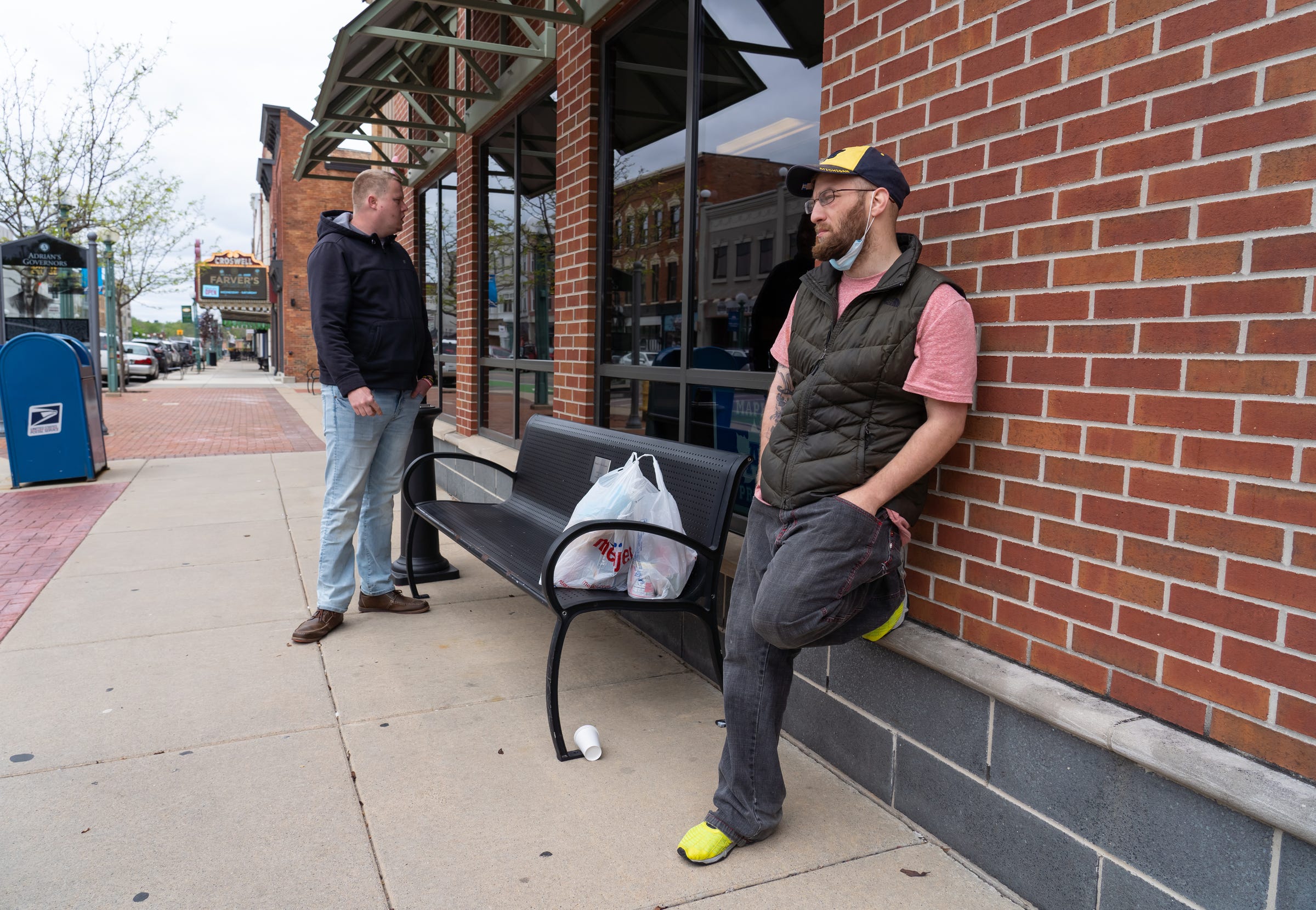 Zechariah Hall (right), 26, of Adrian talks about not getting the COVID vaccine and how he already had COVID-19 while standing outside of the Adrian District Library in downtown Adrian on Wednesday, May 5, 2021. 