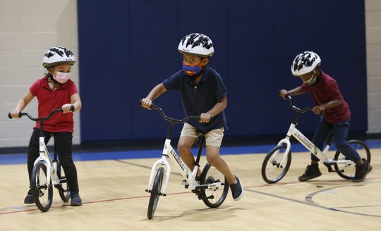 Children make their loops around the gym in the donated bicycles during an All Kids Bike event at Scales Technology Academy in Tempe on May 6, 2021.