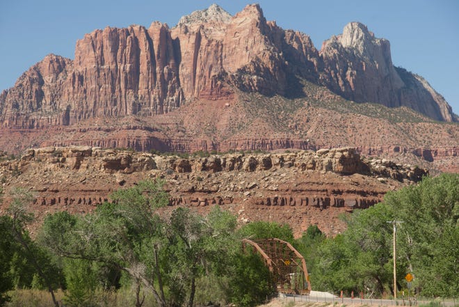 The cliffs above Zion National Park are seen from across the historic Rockville Bridge on May 6, 2021. Rockville and other gateway towns have been heavily impacted by the growth in visitation at Zion, which has become the third-most-visited national park in the U.S.