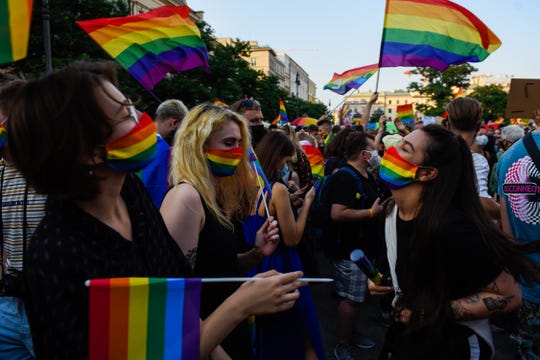 Menschen tragen schützende Gesichtsmasken mit Regenbogenfarben und tanzen während des Gleichstellungsmarsches 2020 am 29. August 2020 in Krakau, Polen.  Die wachsende Feindseligkeit gegenüber der LGBTQ-Gemeinschaft in Polen löste eine Welle von Protesten aus.