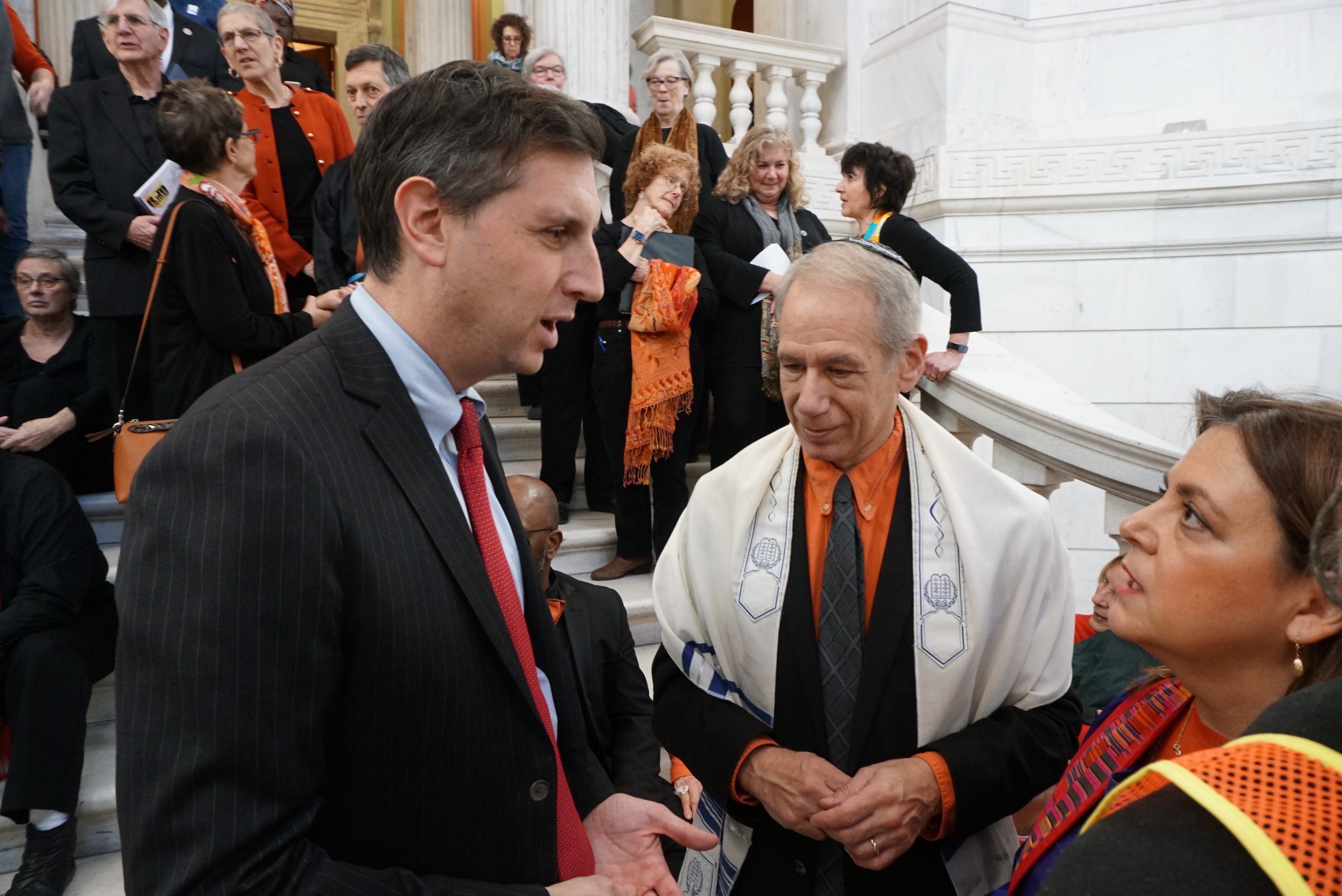 General Treasurer Seth Magaziner speaks with the Rev. Liz Lerner Maclay before a rally against gun violence at the State House last year. At center is Rabbi Howard Voss-Altman of Temple Habonim.