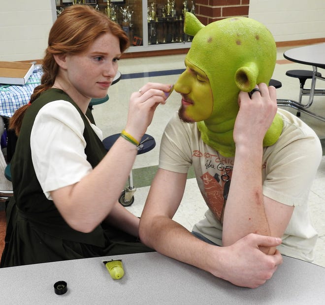 Senior Alyssa Kusmich, who plays Fiona, applies makeup to senior Zade Adkins, who plays Shrek in "Shrek: the Musical." There will be three lives shows this weekend with 125 seats available per show and an online viewing May 22.