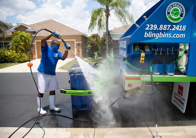 Rod Gadson pressure washes recycle bins in a south Fort Myers neighborhood on Thursday, May 6, 2021. Gadson started Bling Bins LLC after realizing that there must be an easier and more eco-friendly way to clean his garbage and recycling bins.