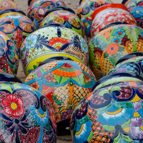 Dozens of brightly painted Mexican flower pots lie