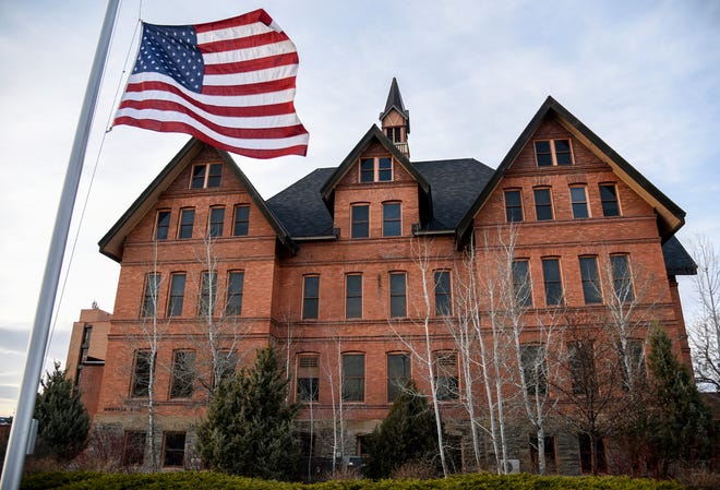 U.S. flag flies at half staff in front of Montana Hall at Montana State University in Bozeman, Mont.