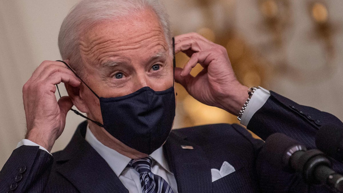 President Joe Biden adjusts his face mask as he speaks during remarks on the implementation of the American Rescue Plan in the State Dining room of the White House in Washington, DC on March 15, 2021.
