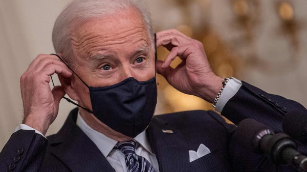 President Joe Biden adjusts his face mask as he sp