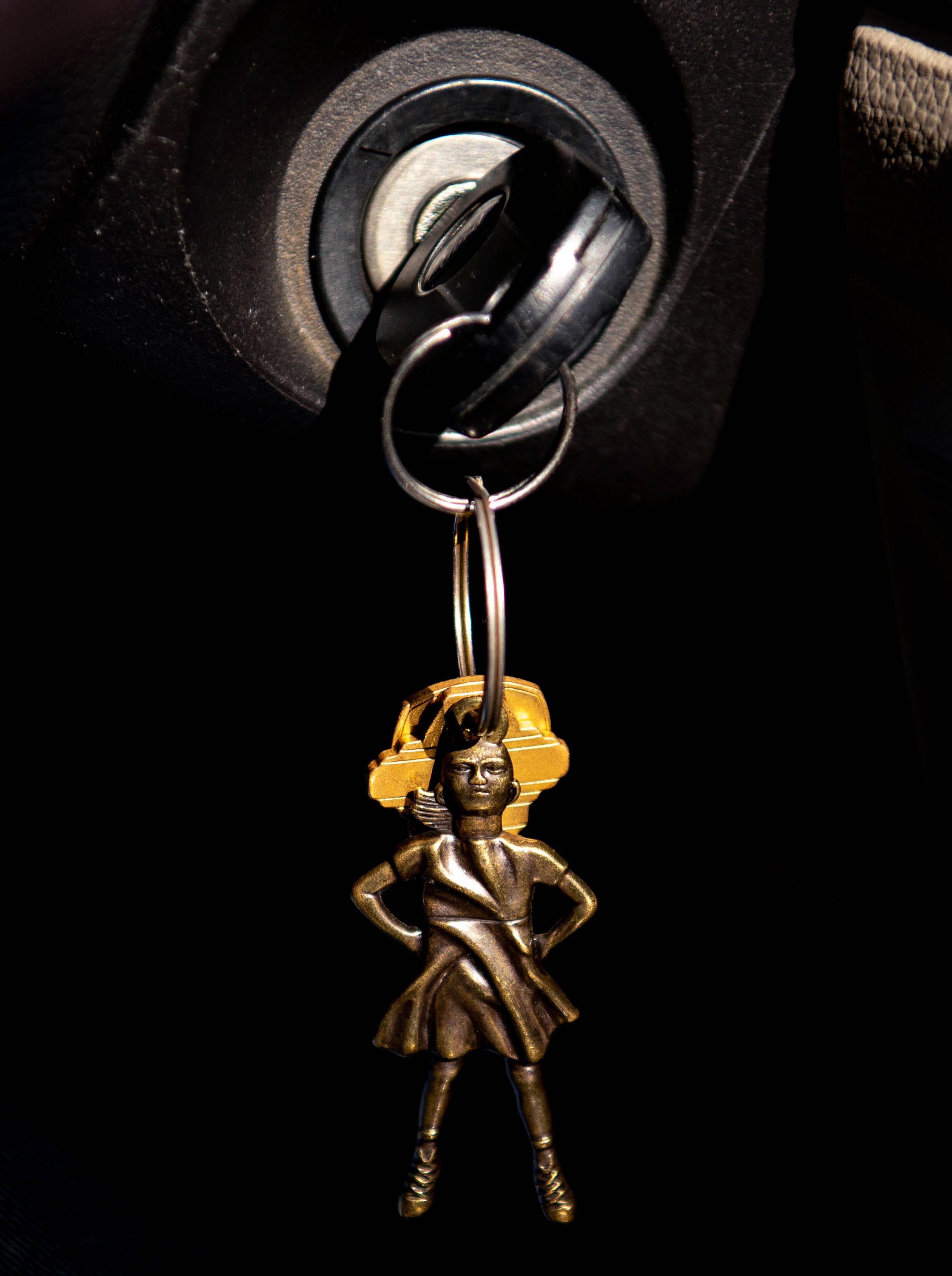 A keychain replica of the Fearless Girl statue on Wall Street is pictured hanging on Guillermina Gutierrez-Martinez's keys on Friday, March 19, 2021, in Seattle, Wash., as she drives to her parent's home an hour north of the city. Gutierrez-Martinez said she bought the keychain on a trip to New York with her family and it reminds her to continue pushing herself. "Girls can do anything guys can do and if this little girl, they put her in front of the giant bull, that goes to show women can do anything." 
