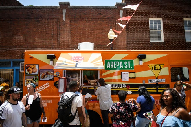 People wait in a long line for food at the Arepa Street food truck on Saturday, June 23, 2018, at the Vegan Festival in Fayetteville. 