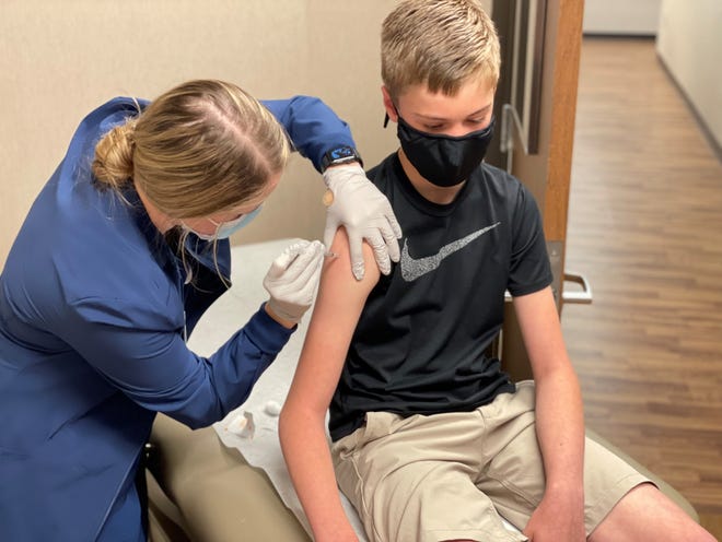 Drew Pociask receives the COVID-19 vaccine from Bailey Fodness, an LPN at Sanford Health on May 12, 2021