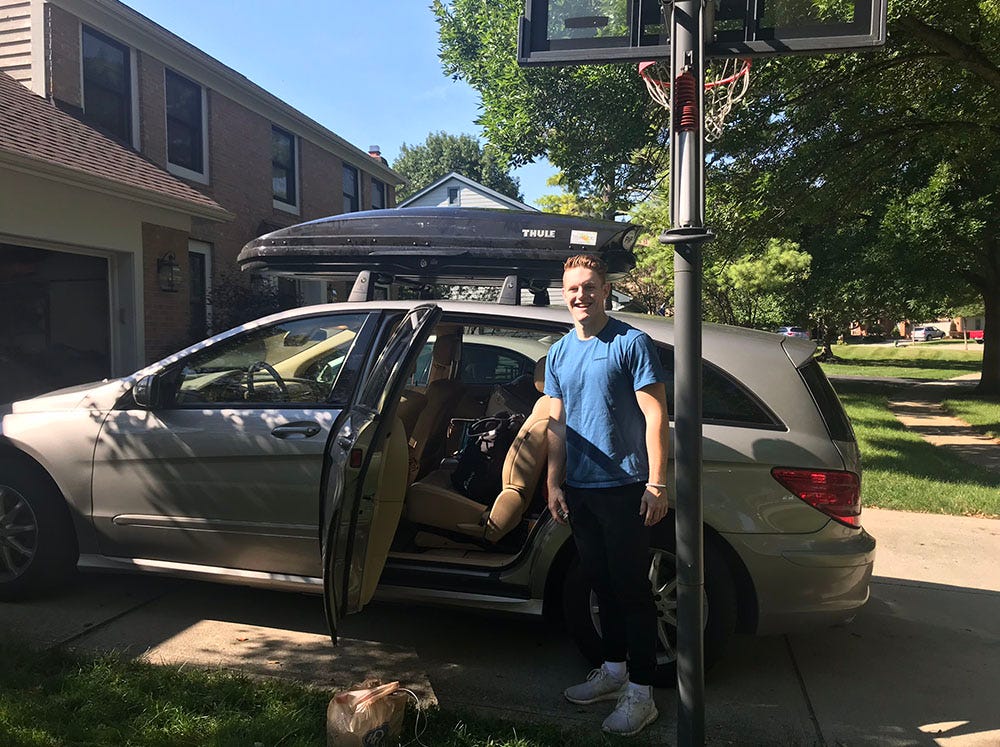 Collin Wiant stands next to the family’s car in Dublin the morning of move-in day at Ohio University in August 2018.