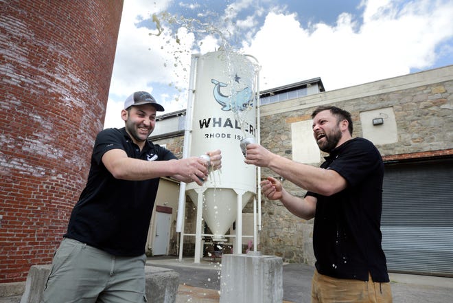 Co-owners Josh Dunlap and Wes Staschke of Whalers Brewing salute their customers with a shaken beer toast at their South Kingstown facility.