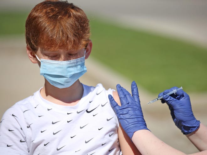 Zach Pluster, 12, who was with his mother, Leeann Pluster of Waukesha, gets a COVID-19 vaccine on Thursday, May 13, at Hayat Pharmacy on West Layton Avenue.