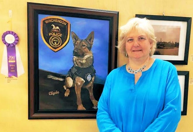 Deborah Giordano, president of the Gardner Area League of Artists, is shown with her painting of K9 Clyde of the Winchendon Police Department.