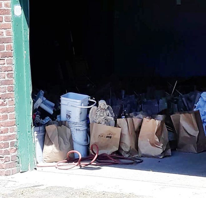 An angel statue and other items removed from gravesites by the New Bedford Cemetery Department sit in a storage garage.