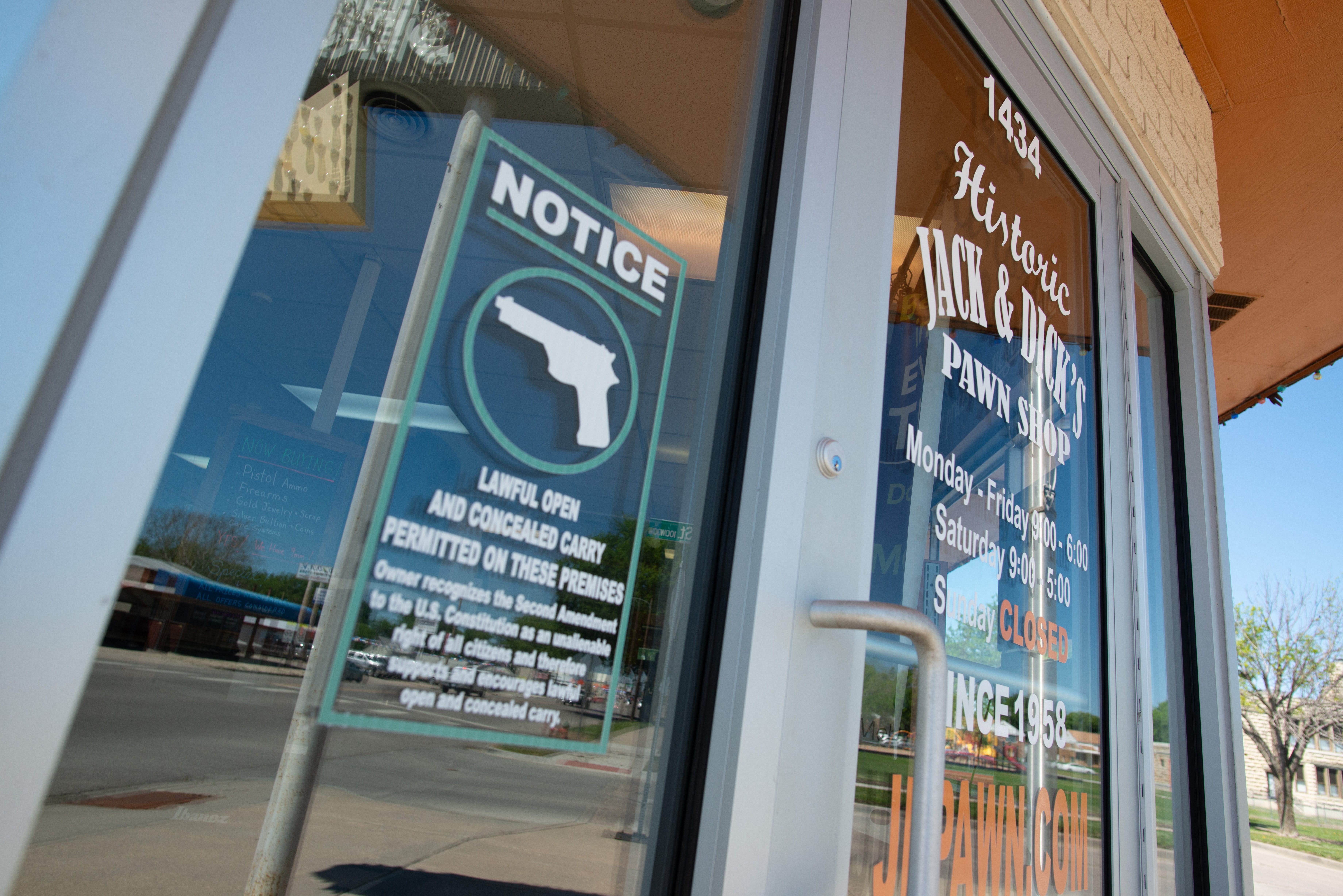 A notice to customers entering Jack and Dick's Pawn Shop in Junction City, Kansas, lets the public know they can carry firearms inside.