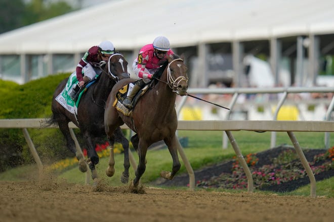 Flavien Prat atop Rombauer, right, breaks away from Irad Ortiz Jr. atop Midnight Bourbon moments before crossing the finish line to win the Preakness Stakes horse race at Pimlico Race Course, Saturday, May 15, 2021, in Baltimore. (AP Photo/Julio Cortez)