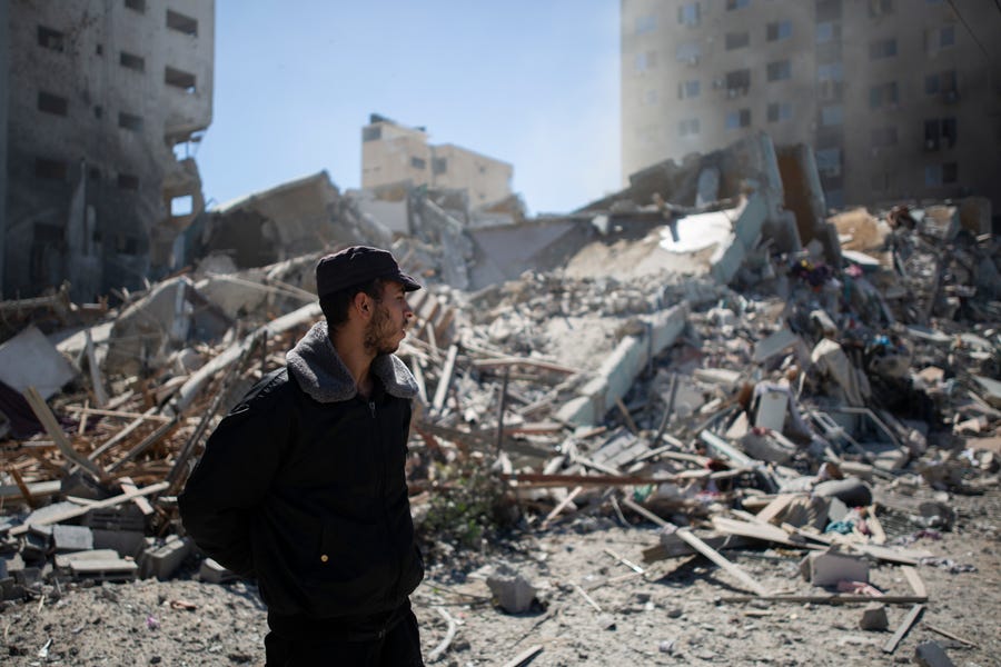 Palestinian policeman stands at rubble of a building destroyed by an Israeli airstrike that housed The Associated Press' offices in Gaza City, Saturday, May 15, 2021. The airstrike Saturday came roughly an hour after the Israeli military ordered people to evacuate the building. There was no immediate explanation for why the building was targeted. The building housed The Associated Press, Al-Jazeera and a number of offices and apartment.