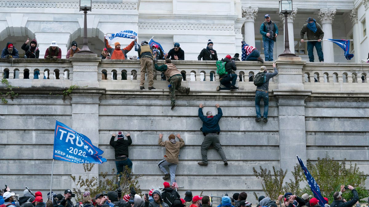 Angry supporters of President Donald Trump scale the west wall of the the U.S. Capitol in Washington on Jan. 6, 2021.