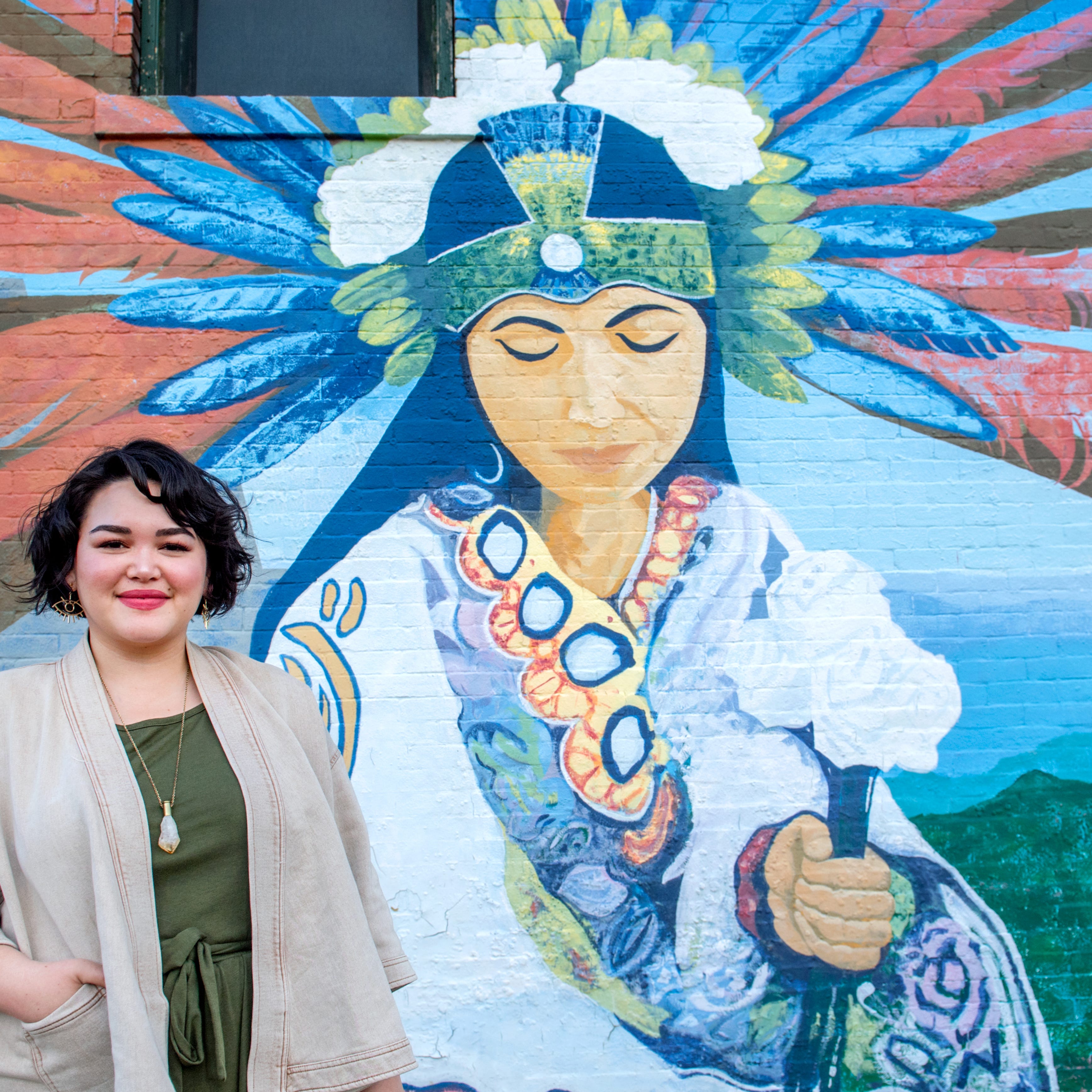 Angie Ostaszewski poses next to a mural near Main and Sheridan in Peoria. The local neighborhood activist has been promoting Peoria through her popular TikTok videos which highlight affordable, often historic, homes in the area.
