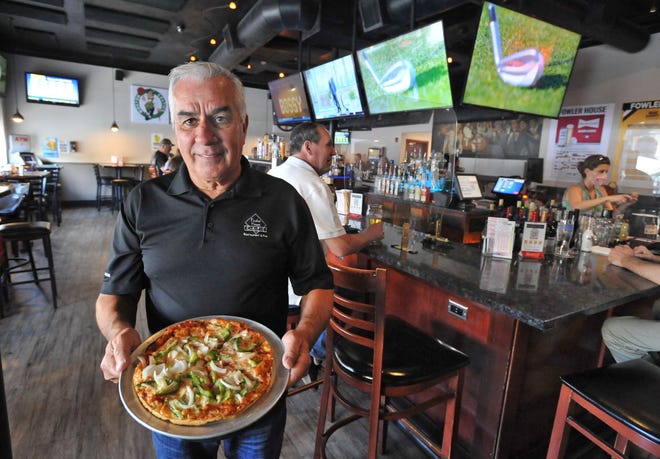 Fowler House owner Bill Rizzotti holds one of his Quincy restaurant's signature pizzas during the eatery's 40th anniversary, Friday, May 14, 2021. Tom Gorman/For The Patriot Ledger