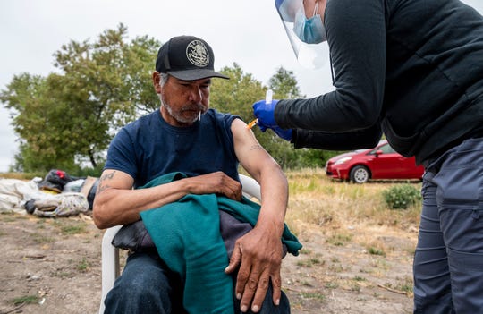 A person experiencing homelessness gets their Johnson & Johnson vaccine during a mobile vaccination clinic hosted by Central Avenue Pharmacy, All-In Monterey, and the Center for Community Health Engagement in Salinas, Calif., on Friday, May 14, 2021. 