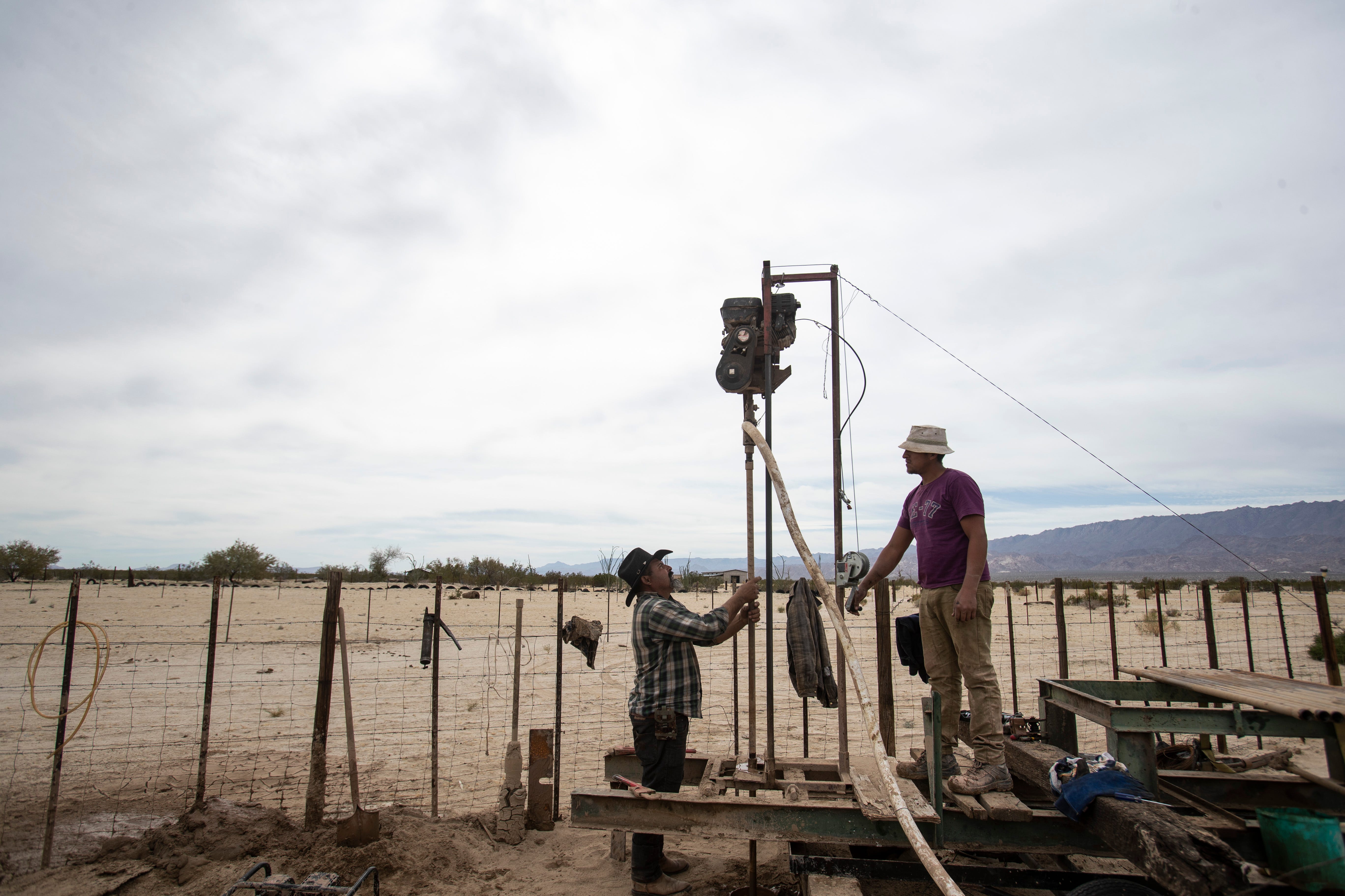 Francisco Baez Salazar, at left, works on a water pump in Laguna Salada.