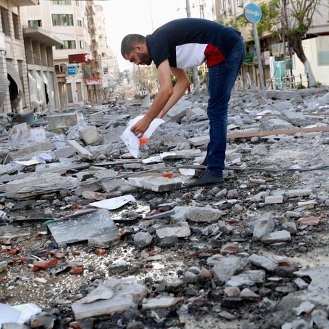 A man inspects the rubble of destroyed commercial 