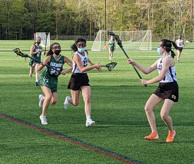 Masks were part of the uniform during last week's girls' lacrosse contest, with Oakmont's Addie Collette (25) trying to advance the ball up the sideline against a pair of Monty Tech defenders.