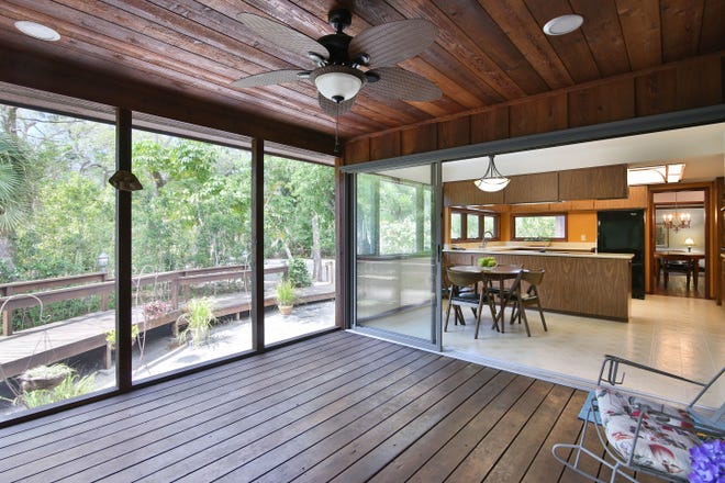 The spacious screened porch that opens off the kitchen has a wood floor, wood walls and wood ceiling.