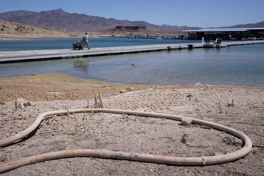 Barbaros Demircar hauls gear down to his boat at Temple Bar Marina on May 10, 2021, in the Lake Mead National Recreation Area, Arizona. The marina’s waterline (ground) length is adjusted as water levels decline and the marina is moved out to deeper water.