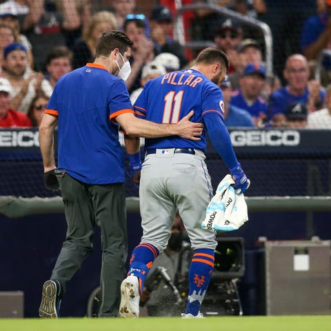 New York Mets outfielder Kevin Pillar is helped of