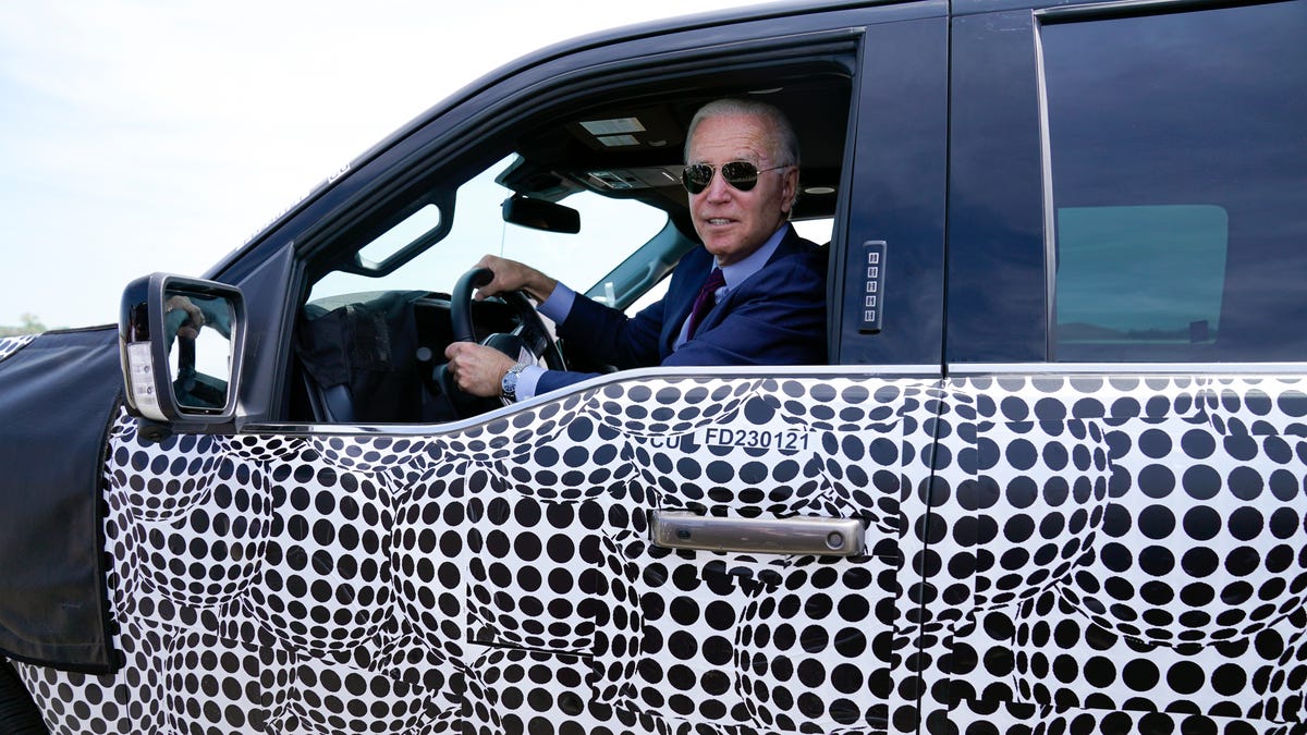 President Joe Biden stops to talk to the media as he drives a Ford F-150 Lightning truck at Ford Dearborn Development Center, Tuesday, May 18, 2021, in Dearborn, Mich.