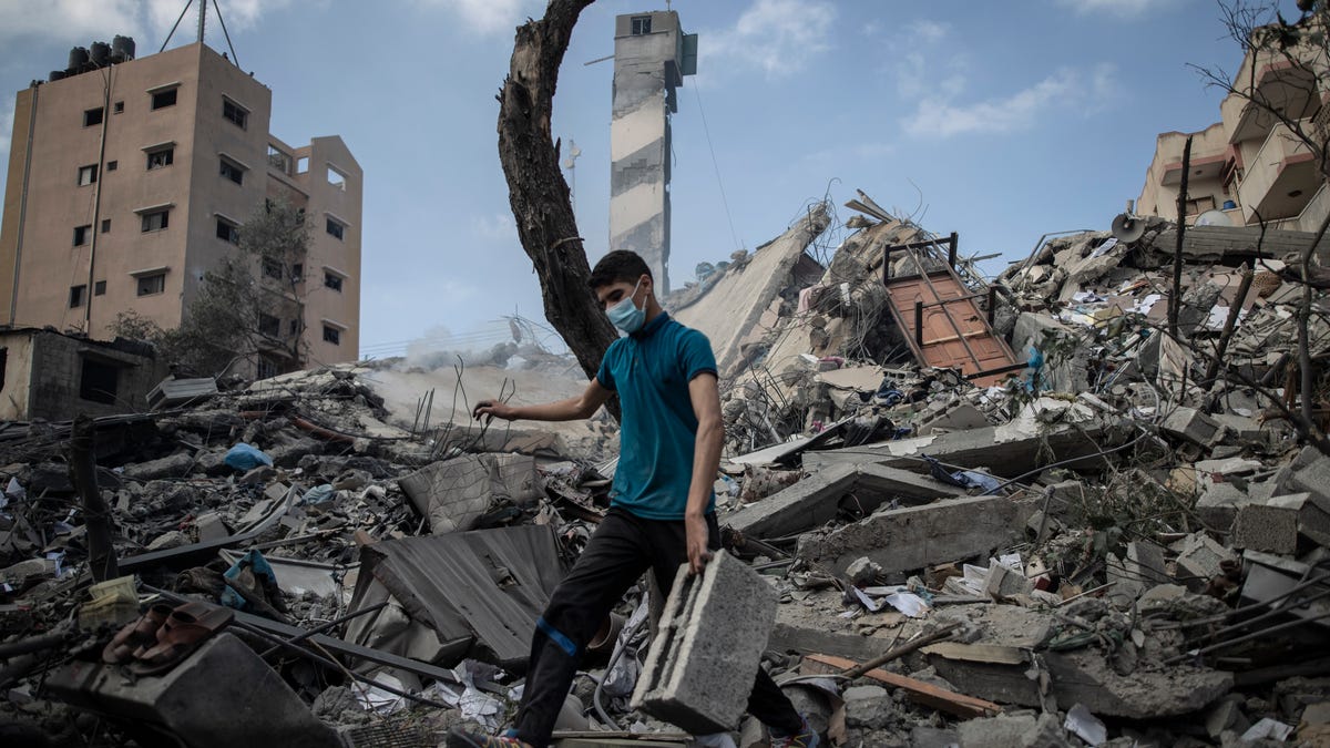 A Palestinian man inspects the damage of a six-story building which was destroyed by an early morning Israeli airstrike, in Gaza City, Tuesday, May 18, 2021. I