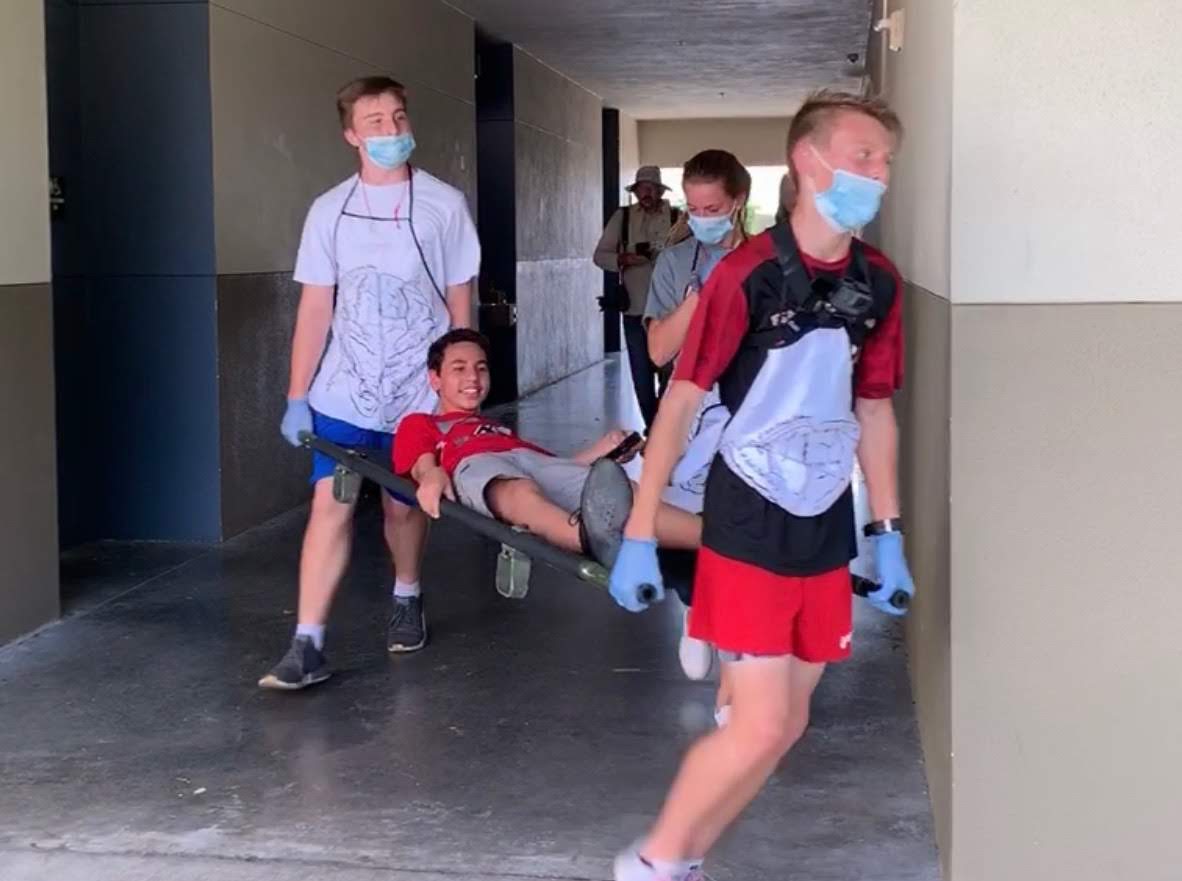 The “body team” from a pandemic simulation in March 2019 at Sarasota Military Academy Prep rushes an “infected” student to the medical ward for treatment.