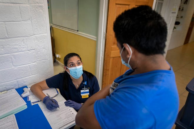 Walmart pharmacist Loretta Giusti registers a person to receive a Covid-19 vaccination at the Esperanza Community Center in West Palm Beach, Florida on May 19, 2021. 