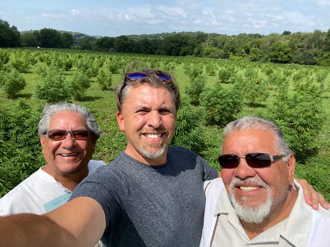 Rob Pero (center) is pictured with his uncles Kim Pero and Ed Pero at a hemp farm in Wisconsin for his new company Canndigenous, which is the first Native American-owned CBD company in Wisconsin.