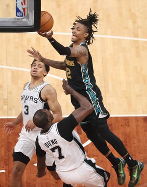 Memphis Grizzlies guard Ja Morant attempts a shot over San Antonio Spurs center Gorgui Dieng during their play-in tournament game at the FedExForum on Wednesday, May 19, 2021.