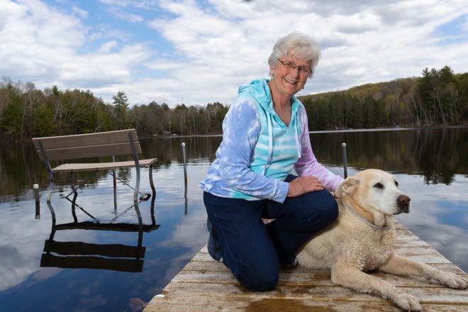 Patricia Voermans with her dog, Tucker, on her dock at her home on Lake Buteau in Gleason. Voermans says broadband always seems just out of reach. "I'm still waiting," she said, after a Frontier Communications technician came to install service, only to discover that it wasn't possible over the copper telephone lines leading to her house.
