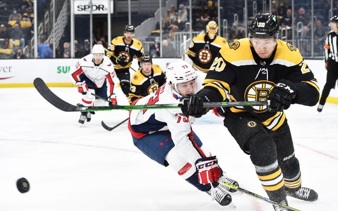 May 21, 2021; Boston, Massachusetts, USA; Boston Bruins center Curtis Lazar (20) clears the puck past Washington Capitals left wing Conor Sheary (73) during the third period in game four of the first round of the 2021 Stanley Cup Playoffs at TD Garden. Mandatory Credit: Bob DeChiara-USA TODAY Sports