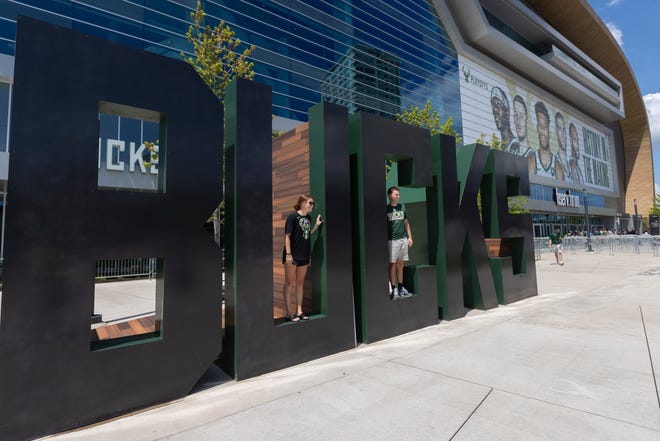 People pose for photos before the first-round playoff game between the Milwaukee Bucks and Miami Heat on Saturday outside Fiserv Forum.