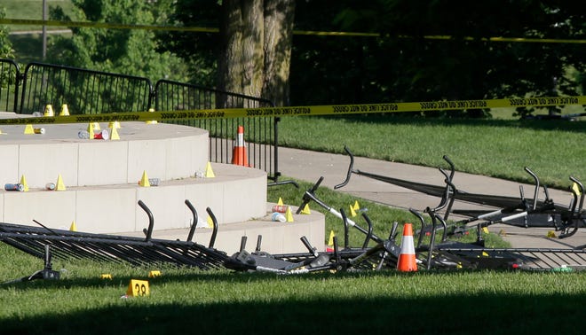 Crime scene tape surrounds Bicentennial Park in downtown Columbus on Sunday morning, May 23, 2021, as Columbus police investigate a shooting late Saturday night that killed one and injured several others. The small yellow cones all over the stage and surrounding grass areas mark bullet casings and other evidence.
