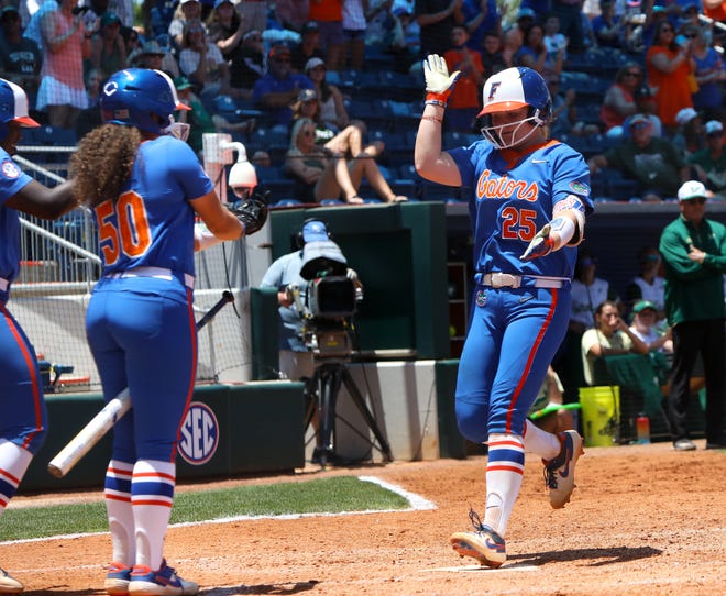 Florida catcher Julia Cottrill does the Gator Chomp as she approaches home plate Sunday after hitting a home run against South Florida during the final game of the Gainesville Regional at Katie Seashole Pressly Stadium.
