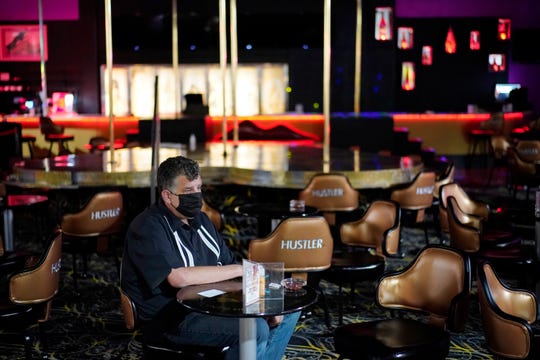 Jeff Cantrell waits at Larry Flint’s Hustler Club strip club after getting his second dose of a COVID-19 vaccine Friday in Las Vegas. City officials held a pop-up vaccine clinic at the strip club to encourage more people to get vaccinated.