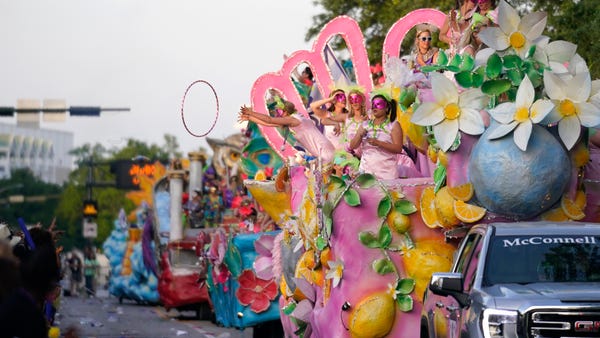 A trinket is thrown from a float during a parade i
